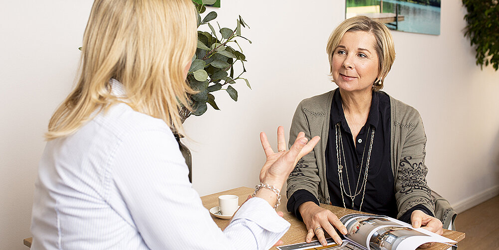 Eine Immobilienberaterin beantwortet die Fragen einer Kundin 