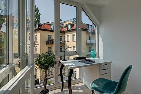 Helles Homeoffice mit Panoramafenstern und stilvollem Schreibtisch in Münchener Altbauwohnung – möbliertes Wohnen mit Arbeitskomfort bei Mr. Lodge.