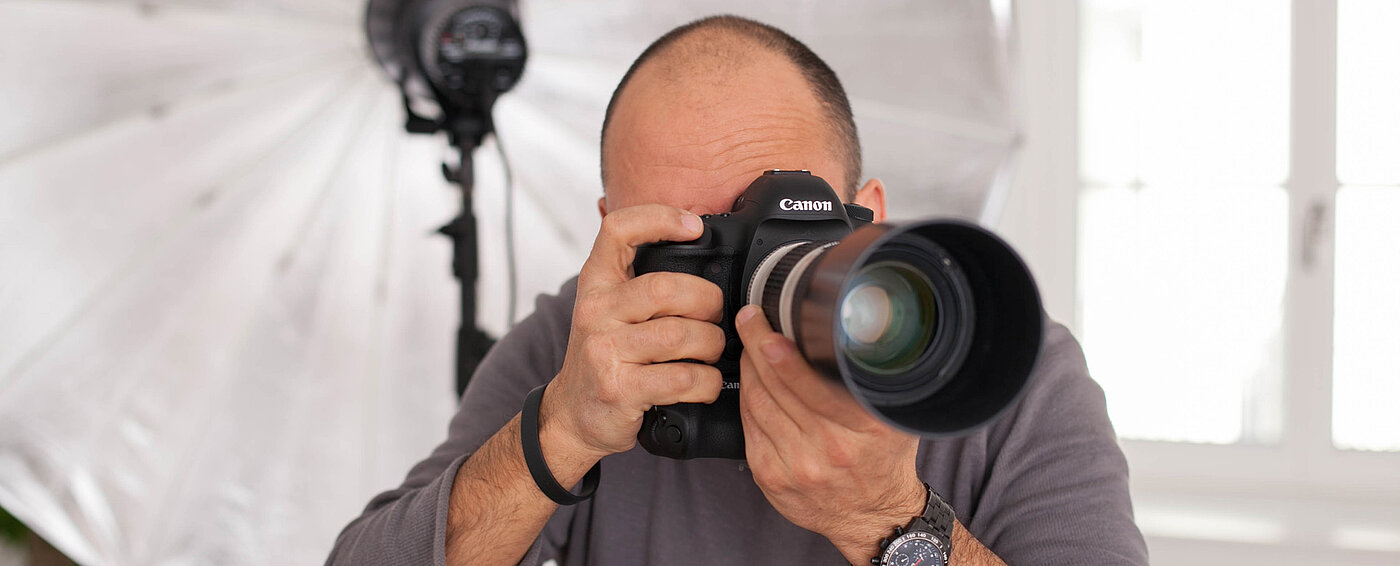 Das Bild zeigt einen Fotografen mit seiner Kamera für die Immobilienaufnahmen